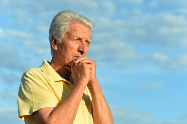 Portrait of senior man against blue sky