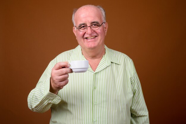 Portrait of senior man holding coffee cup en surpoids