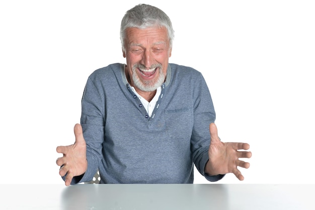 Portrait of senior man sitting at table isolé sur fond blanc