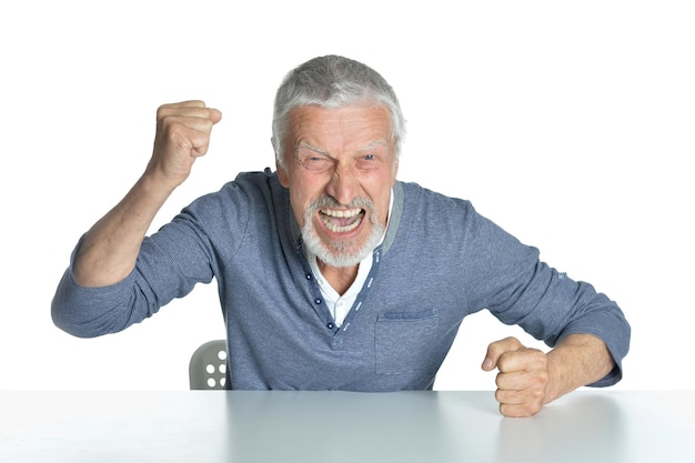 Portrait of senior man sitting at table isolé sur fond blanc