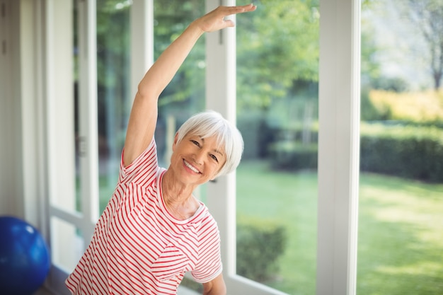 Portrait of senior woman exercice d'étirement à la maison