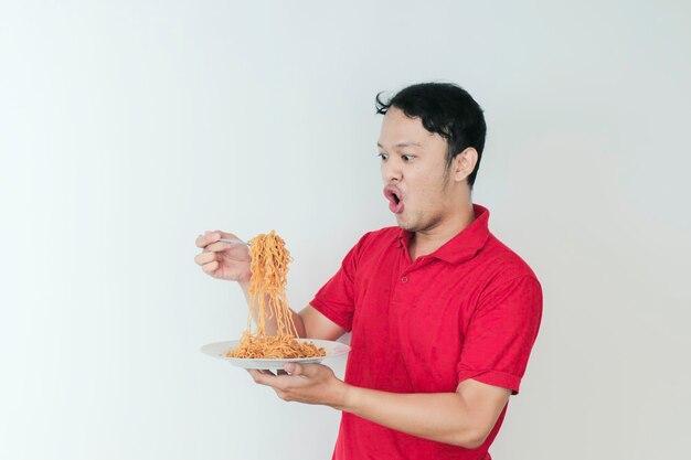 Portrait of Shock and Wow Young Asian man enjoy noodles Eating lunch concept