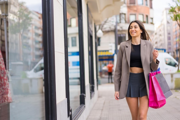 Portrait of shopping woman with bags in the city concept sales consumérisme lèche-vitrines