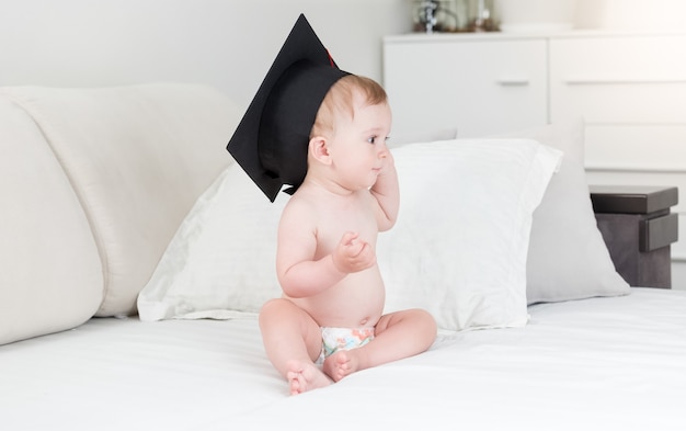 Portrait of smiling baby boy en couches et chapeau de graduation