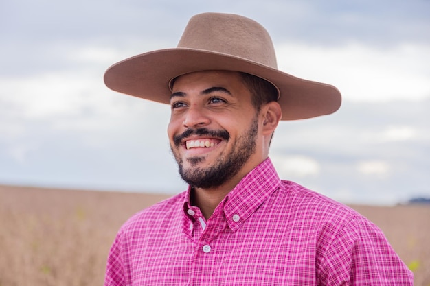 Portrait of smiling beautiful young male farmer Man at farm in summer day Activité de jardinage Homme brésilien