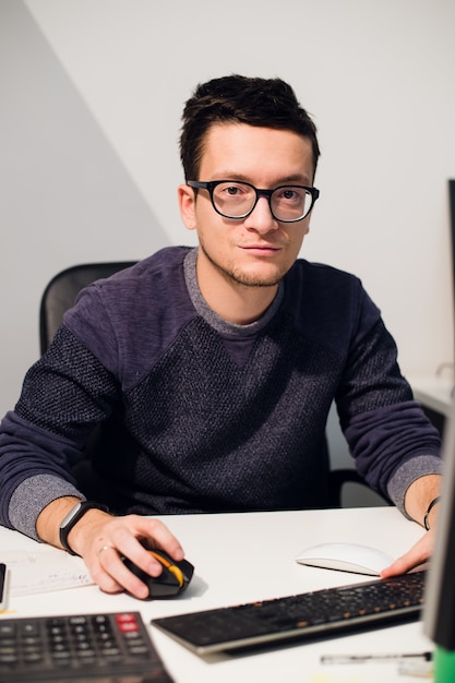 Portrait of smiling casual businessman working with computer in the office