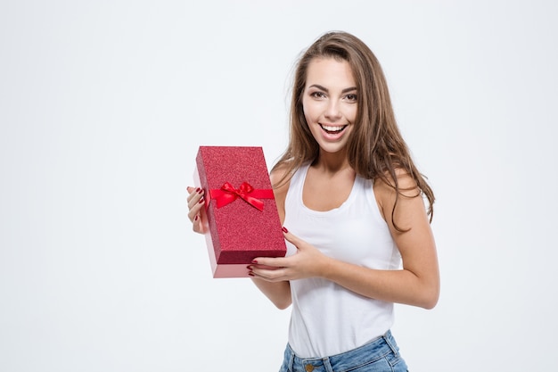 Portrait of a smiling casual woman holding gift box isolé sur fond blanc