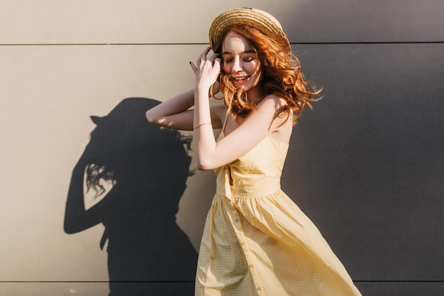 Portrait of smiling cute girl gingembre porte robe jaune et chapeau d'été