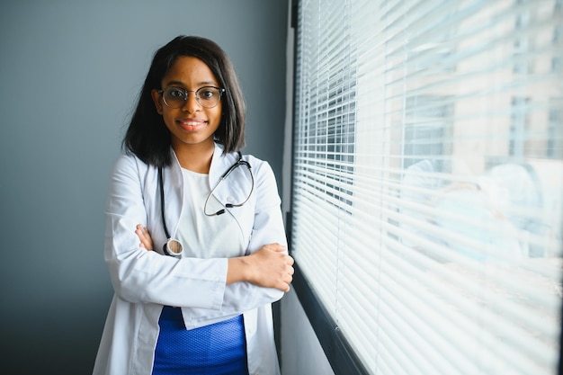 Portrait of smiling female doctor wearing white coat avec stéthoscope dans le bureau de l'hôpital