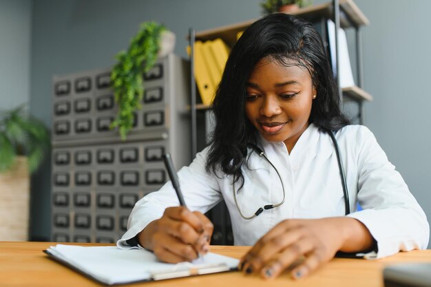 Portrait of smiling female doctor wearing white coat avec stéthoscope dans le bureau de l'hôpital