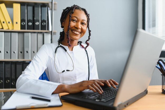 Portrait of smiling female doctor wearing white coat avec stéthoscope dans le bureau de l'hôpital