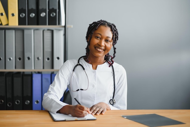 Portrait of smiling female doctor wearing white coat avec stéthoscope dans le bureau de l'hôpital