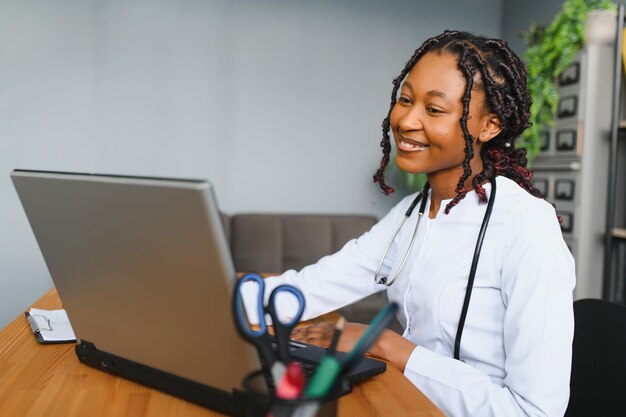 Portrait of smiling female doctor wearing white coat avec stéthoscope dans le bureau de l'hôpital