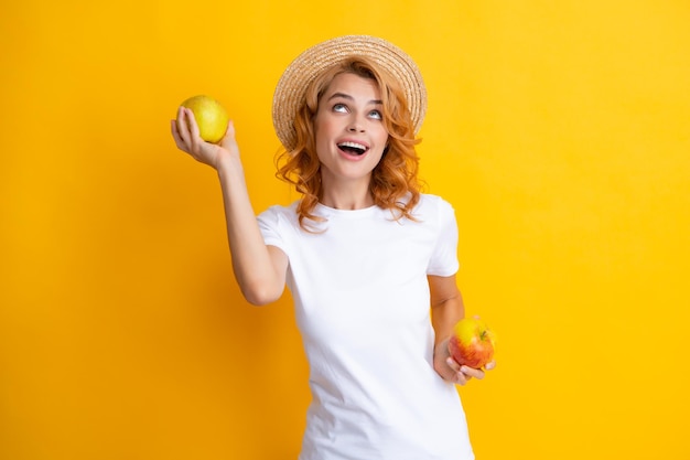 Portrait of a smiling happy girl with apple isolé sur fond jaune