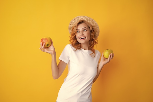 Portrait of a smiling happy girl with apple isolé sur fond jaune