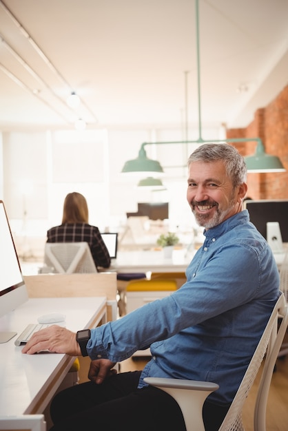 Portrait of smiling male exécutif assis au bureau