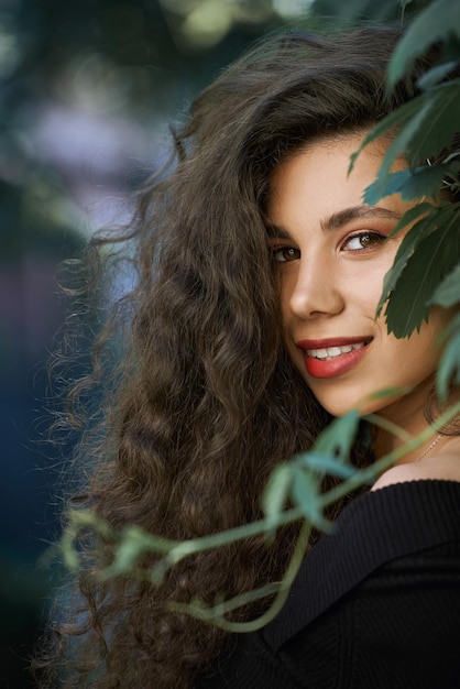 Portrait of smiling model parmi les feuilles de vigne