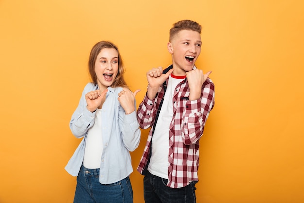 Portrait of a smiling teenage couple pointant du doigt