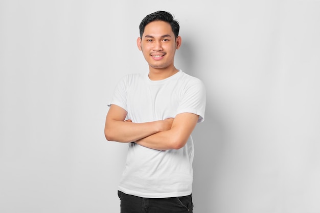 Portrait of smiling young Asian man bras croisés poitrine et à la confiance isolé sur fond blanc