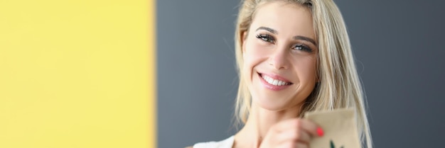 Portrait of woman holding craft package with cannabis green leaf sign on paper container female