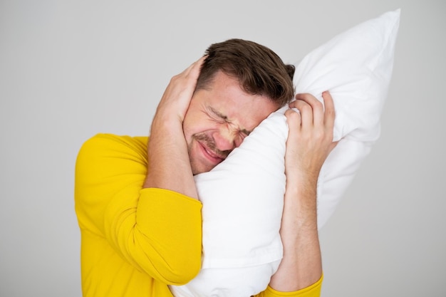 Portrait of Young Caucasian man in bed en colère contre le bruit