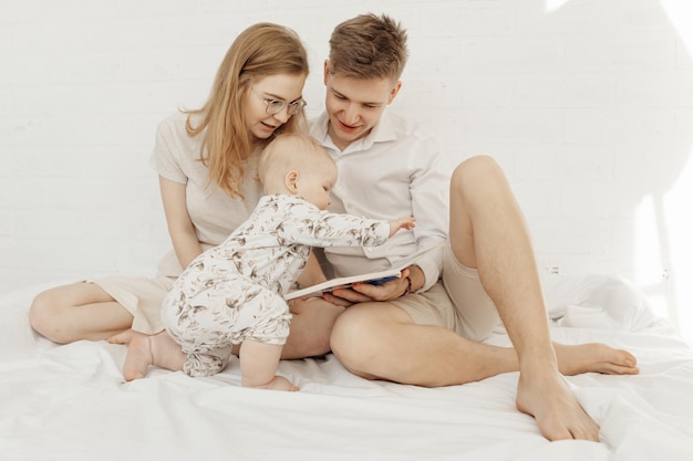 Portrait of young happy attractive family with cute bébé bébé chérubin bambin en vêtements blancs si