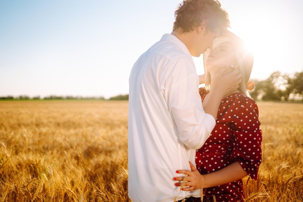 Portrait of young happy couple hugging on the field on the sunset Profiter du temps ensemble