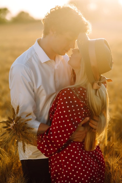 Portrait of young happy couple hugging on the field on the sunset Profiter du temps ensemble