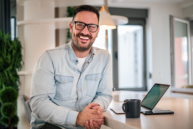 Portrait of young smiling businessman businessman in office looking at camera