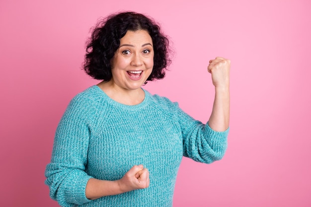 Portrait of young woman doing a winner hands up shouting yes isolé sur fond de couleur pastel