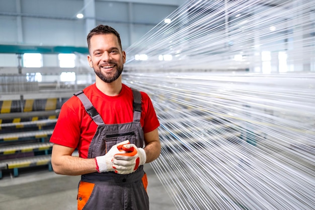 Photo portrait d'un ouvrier masculin debout dans une usine textile près de la machine à coudre