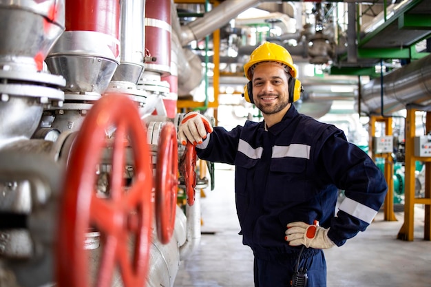 Portrait d'ouvrier d'usine debout près des pompes à pression à l'intérieur de l'usine d'énergie de chauffage