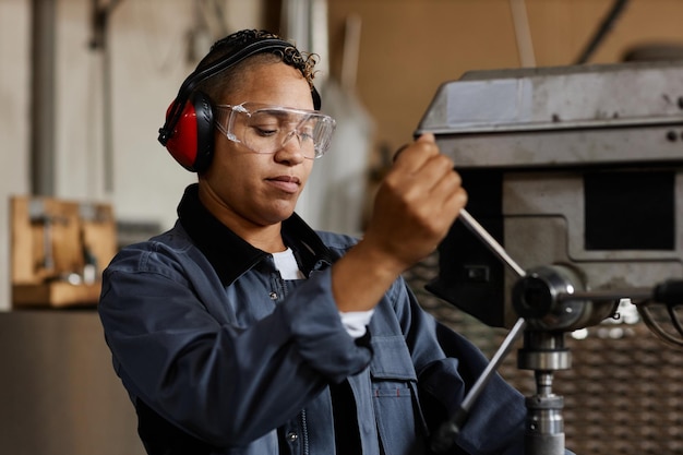 Portrait d'une ouvrière exploitant des unités de machine dans un atelier industriel, espace de copie