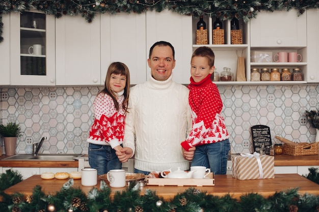 Portrait de papa jovial avec fils et fille dans la cuisine