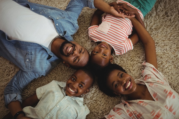 Photo portrait de parents et enfants heureux allongé sur un tapis