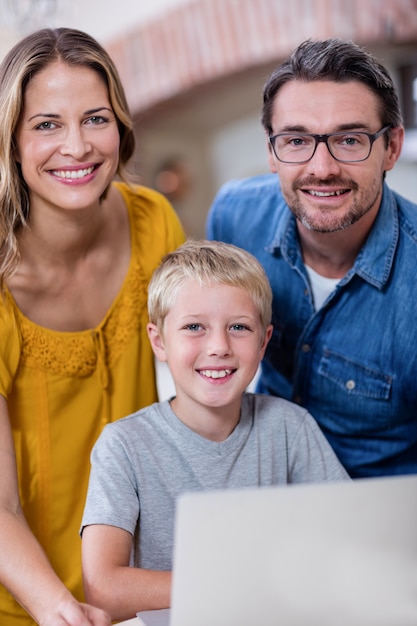 Portrait, parents, fils, ordinateur portable, cuisine