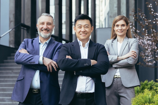 Portrait d'un patron asiatique prospère et heureux avec ses divers hommes d'affaires de l'équipe de rêve à l'extérieur
