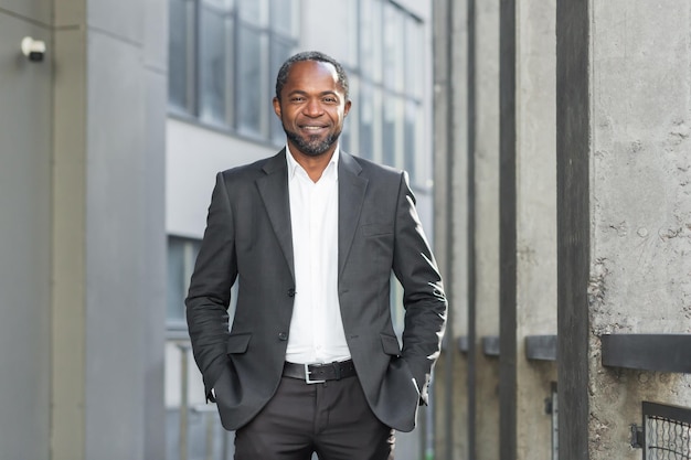 Portrait d'un patron de directeur d'homme d'affaires afro-américain prospère debout dans un costume à l'extérieur de la