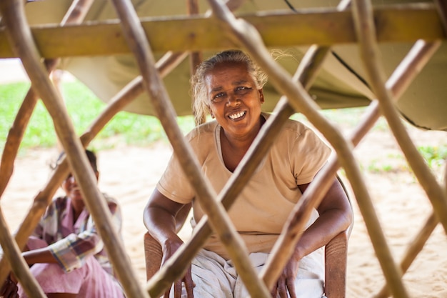 portrait d'une pauvre femme indienne âgée derrière une clôture en forme de treillis