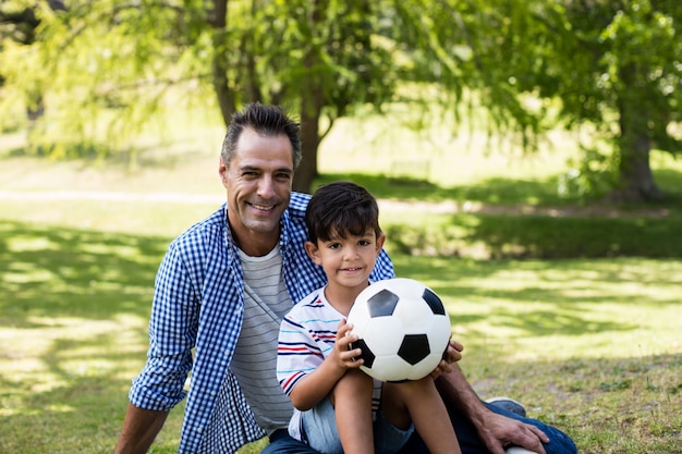 Portrait de père et fils assis dans le parc