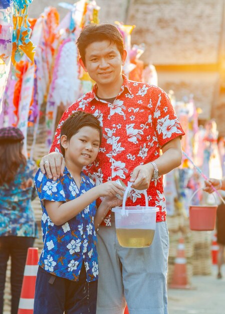 Photo portrait d'un père et d'un fils avec un seau dans la ville pendant l'événement