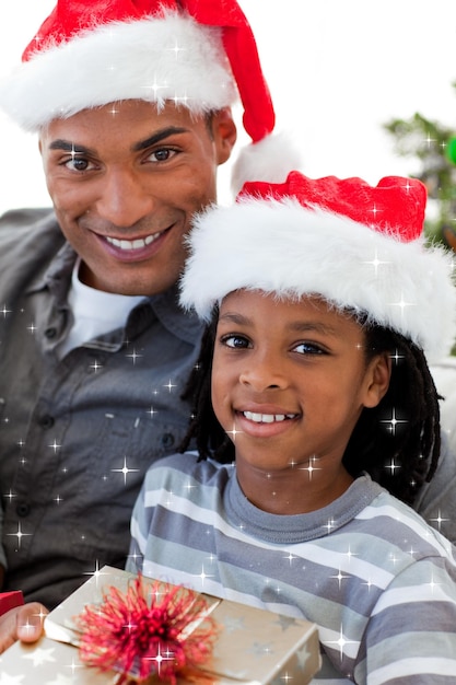 Portrait d'un père et fils tenant un cadeau de Noël avec des étoiles scintillantes