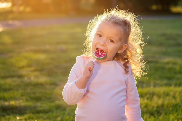 Portrait d'un père heureux et de sa petite fille avec des sucettes dans le parc