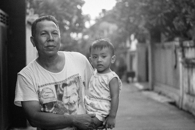 Photo portrait d'un père avec sa petite-fille debout à l'extérieur