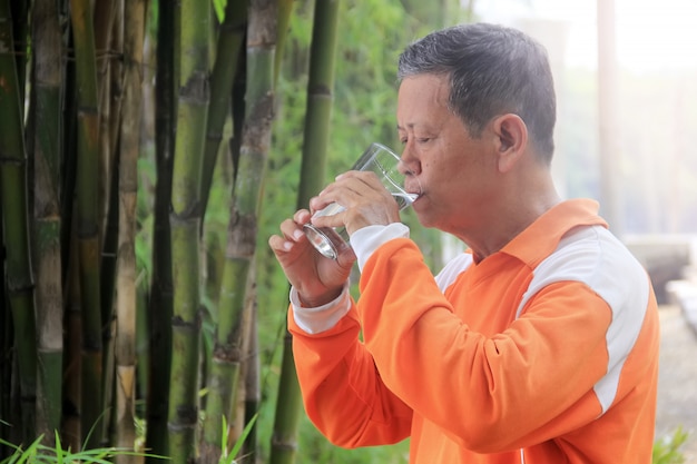 Portrait d'une personne âgée buvant de l'eau à l'aide d'un verre