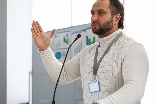 Portrait de personne de sexe masculin sérieux parlant dans le microphone. Bel homme d'affaires en détournant les yeux avec sérieux et calme