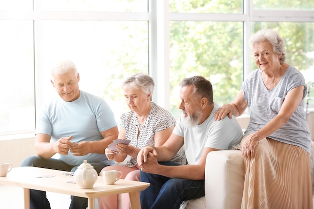 Portrait de personnes âgées jouant aux cartes en maison de retraite