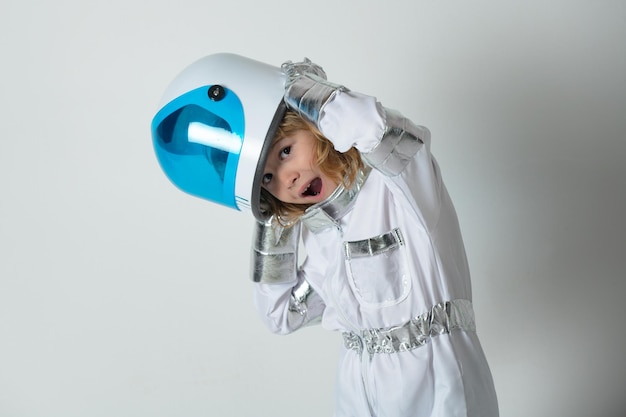 Portrait d'un petit astronaute étonné en casque et combinaison spatiale de protection astronaute drôle de petit garçon