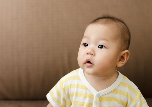 Photo portrait de petit bébé asiatique petit bébé assis et regardant vers la gauche