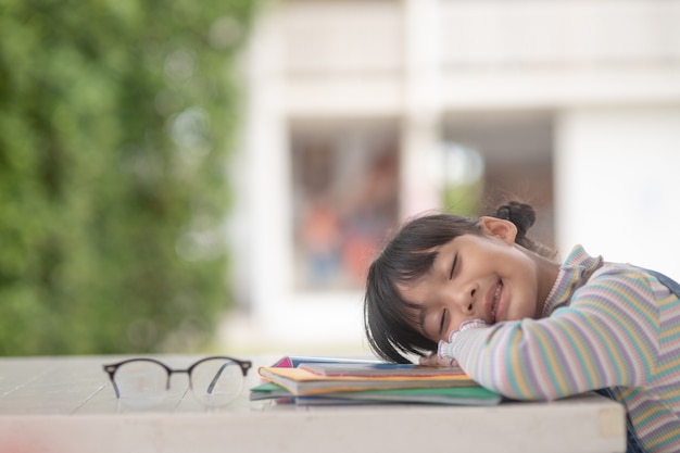 Portrait de petit enfant asiatique heureux dormant sur un livre